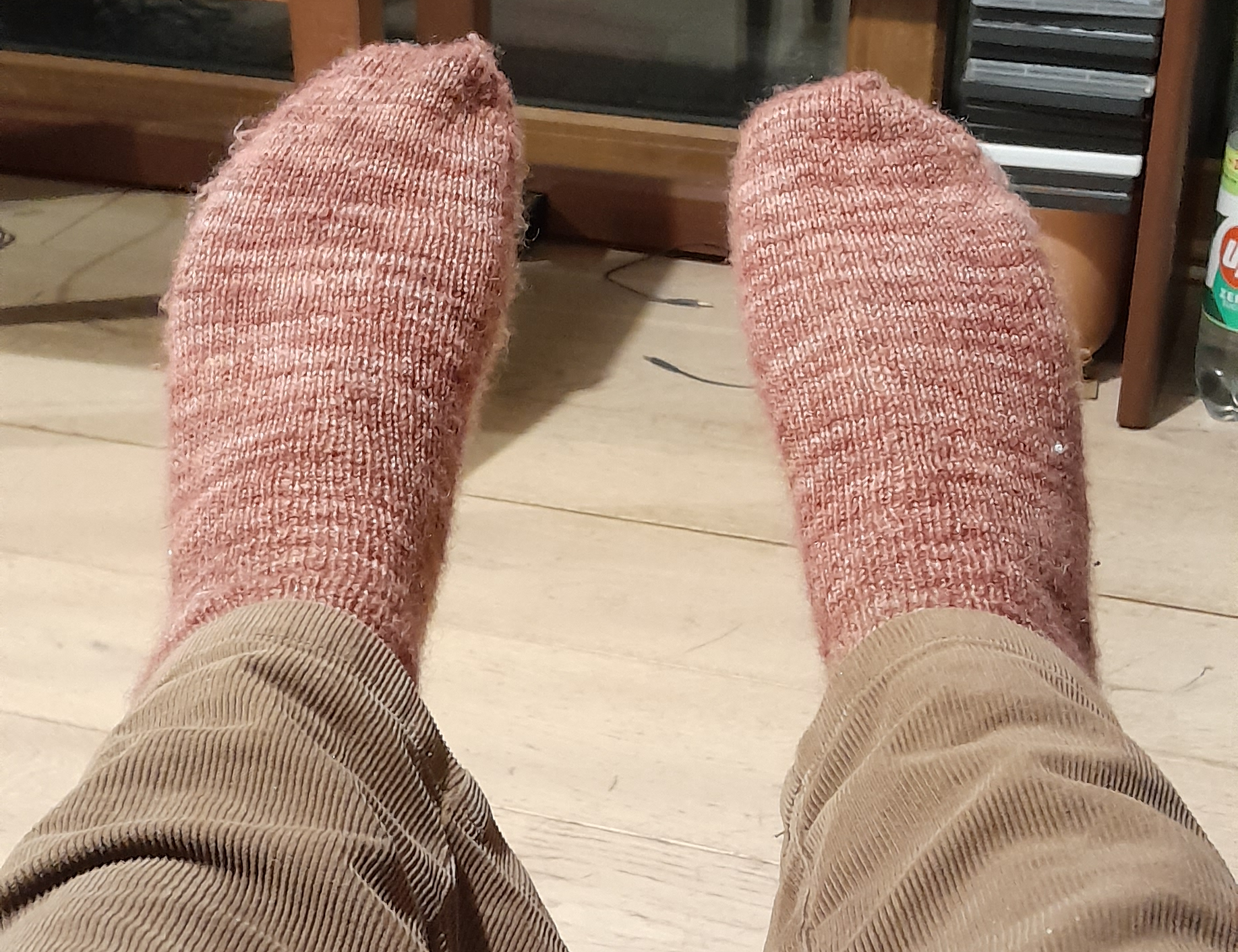 a pair of socks made from variegated pink and coral yarn.